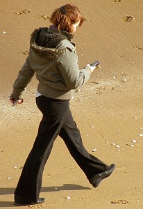 Frau mit Handy am Strand: Kostenhürde für EU-Datenroaming bröckelt (Foto: FlickrCC/Funkdooby)