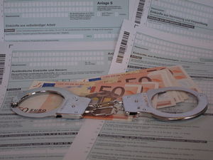 Handschellen auf Geld: Staat setzt Ansprüche durch (Foto: pixelio.de, IESM)