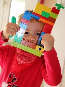 Kind mit Lego-Kreation: Spielen fördert Entwicklung (Foto: pixelio.de, H. Souza)
