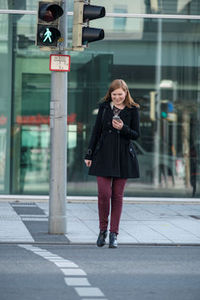 Frau mit dem Handy in der Hand: bringt sich in Lebensgefahr (Foto: dekra.de)