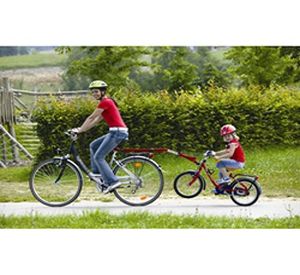 Porträt Eines Kleinen Jungen, Der Auf Einem Abschlepp-Tandem-Fahrrad Fährt,  Das An Den Vater Auf Der Städtischen Straßenansicht Von Vorne Angeschlossen  Ist Lizenzfreie Fotos, Bilder und Stock Fotografie. Image 166722158.