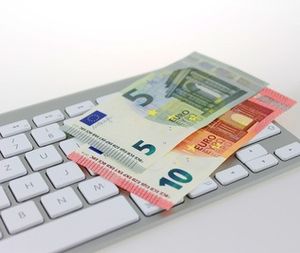 Geld auf Tastatur: Viele nutzen Online-Banking (Foto: Marc Boberach, pixelio.de)