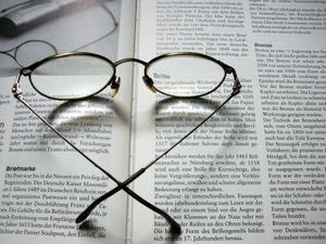 Brille auf Text: Gehirn reagiert bei Alzheimer langsam (Foto: pixelio.de/marika)