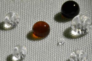 Tropfen kullern wie Perlen über den beschichteten Stoff (Foto: MIT)