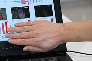 Experiment: mit transparenten Sensoren präparierte Hand (Foto: ntu.edu.sg)