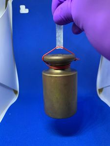 Gewicht am dünnen Röhrchen: so belastbar ist das Material (Foto: epfl.ch/en)