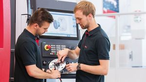 EMCO-Mitarbeiter messen ein CNC-gefrästes Stück aus (Foto: EMCO GmbH)