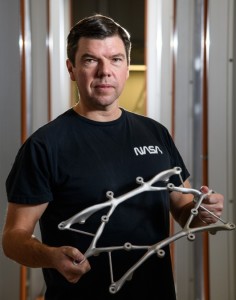 Ryan McClelland mit einem vom Computer konstruierten Bauteil (Foto: Henry Dennis, nasa.gov)