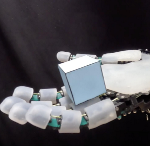 Roboterhand: Gleich schließen sich die Finger sanft um die kleine Schachtel (Foto: epfl.ch)
